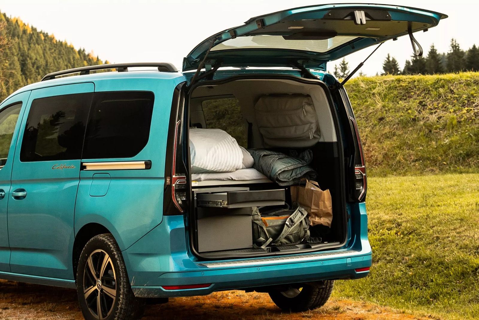 Volkswagen Nutzfahrzeuge Caddy California, Blick auf das Bett durch den ge&ouml;ffneten Kofferraum